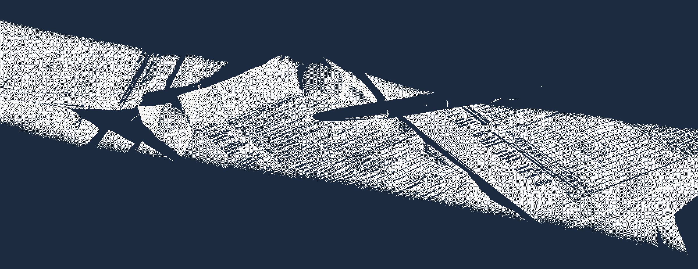 Tax forms and worksheets spread across a desk in raking light, with a pen resting across them.
